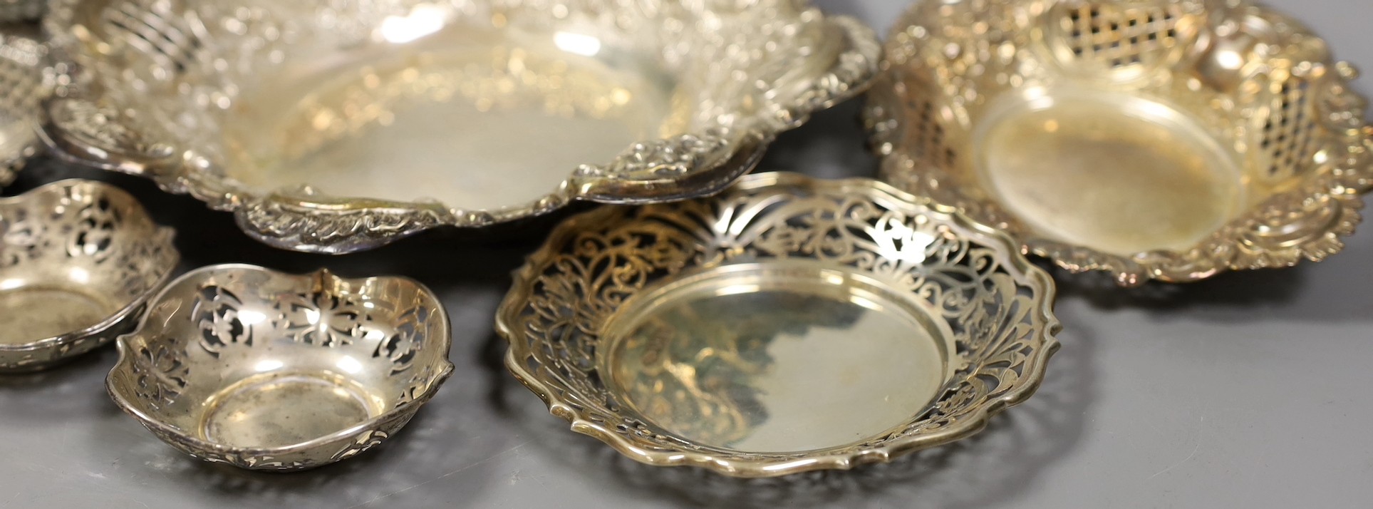 Seven assorted Victorian and later pierced silver nut or bonbon dishes, largest 22.6cm in diameter, 19.4oz.